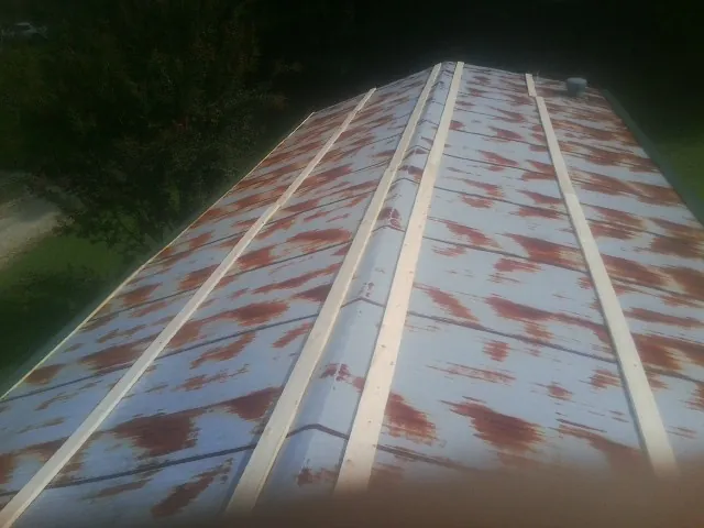Rusted metal roof panels with new wood purlins before replacement — Storm Damage Roof Repair in Sabula by Roofing Brothers
